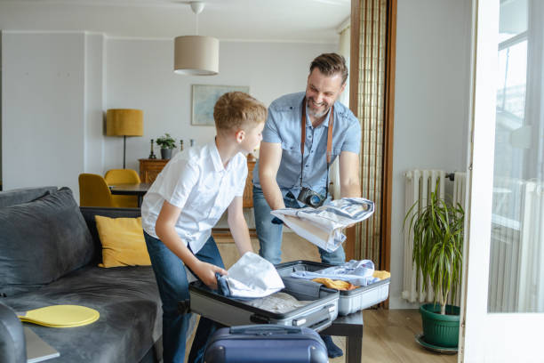 istock Father and son packing for a trip and smiling 2161393036