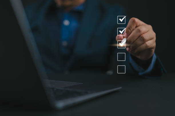 istock Checklist concept. Questionnaire with checkboxes, filling survey form online. Businessman using pen to checking mark on checkboxes on virtual screen. 2161396325