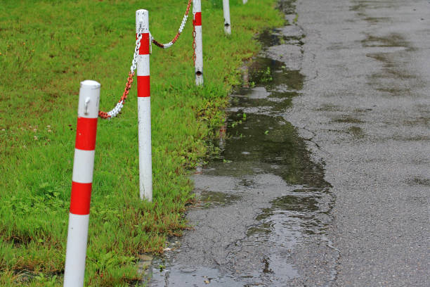 A rain-soaked road with a barrier