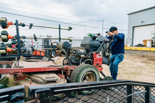 Professional Commercial Landscaper Man Unloading a Riding Lawn Mower from a Trailer for a day of Lawn Care in the Southern Mid-USA