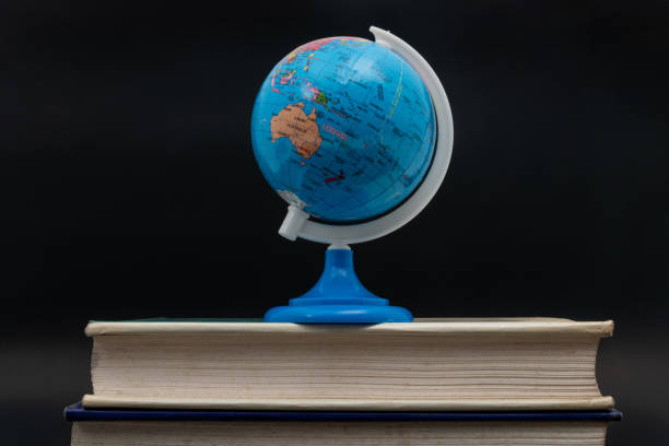 istock Globe and old books on black background. Back to school 2161399991