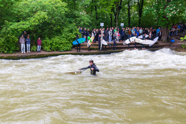 Munich, Germany - 22 June 2024: Surfer at the Eisbach wave in the centre of Munich on the Isar river