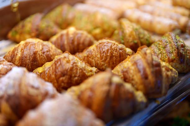 istock Freshly baked croissants displayed on a shelf in a bakery shop 2161406304