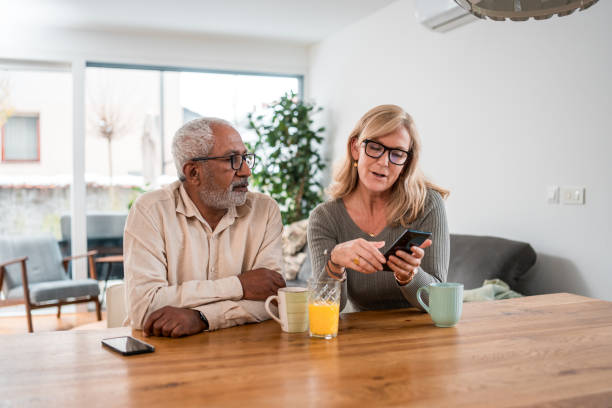 istock Senior Mixed Race Male and Caucasian Female Using Smartphone in Kitchen 2161410099