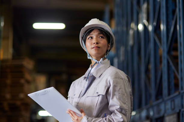 istock A woman wearing work clothes inspecting a factory 2161410512