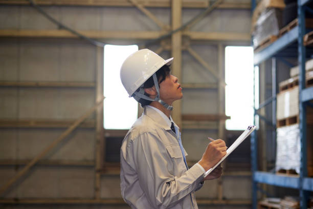 istock A man wearing work clothes inspecting a factory 2161410524