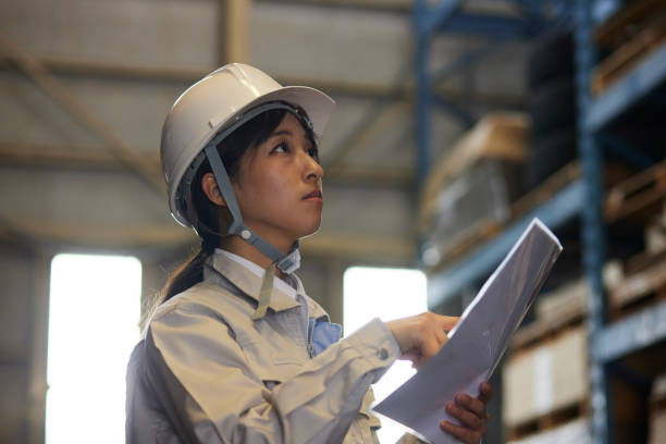 istock A woman in work clothes inspecting a factory 2161410564