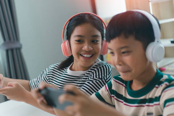 istock Two children are playing a video game on a cell phone 2161410837