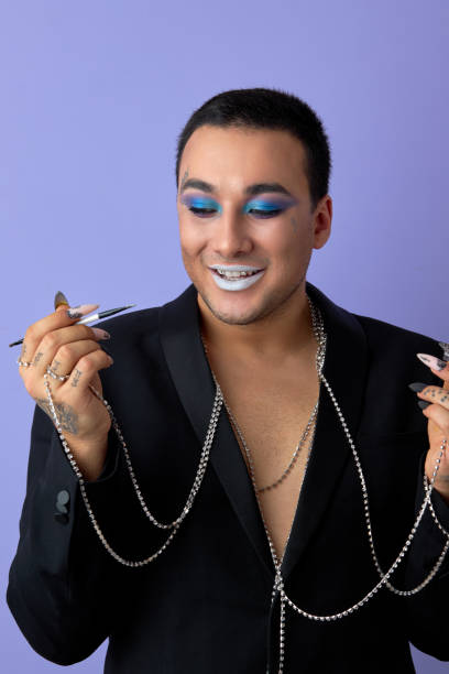 istock Young smiling transvestite man applying cosmetics on face, doing make-up, isolated 2161412509