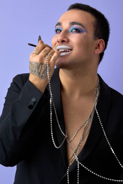 istock fashionable transvestite man applying cosmetics on face, doing make-up, isolated 2161412517