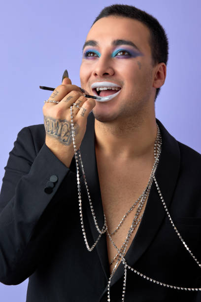 istock Young smiling transvestite man applying cosmetics on face, doing make-up, isolated 2161412794