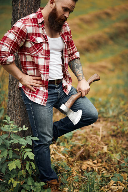 istock man with red shirt and axe posing near tree 2161414136