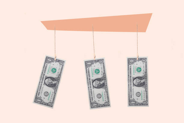 istock Someone holding one dollar banknotes with clothespins on a clothesline 2161414763