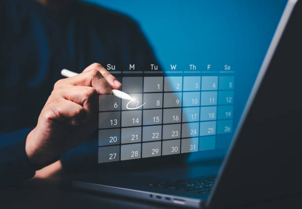 istock Secretary uses a computer with virtual calendar screen to make appointment reminders or meeting agenda on the calendar. Time management concept. People manage schedule agenda for time-effective work. 2161414815