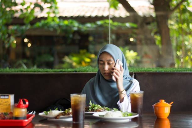 istock Tired business woman using smartphone while lunch at restaurant 2161419440