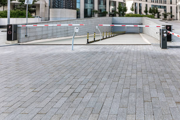 istock underground garage parking entrance with closed automatic boom barrier. 2161421788