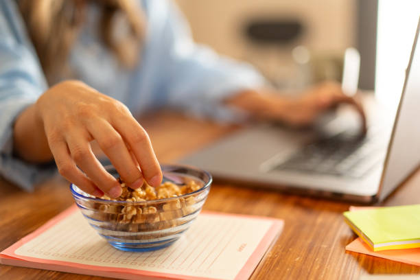 Healthy Snack at Work - Hand Reaching for Nuts on Desk