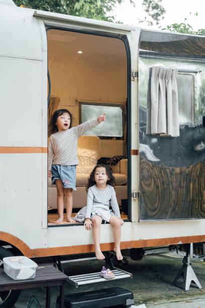 istock Cozy Twin Sisters Relaxing in a Camper Van 2161423561