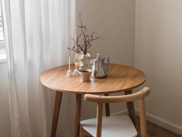 coffee break. a cup of coffee, a metal coffee pot, decor, candles on a round wooden table in the living room - table ronde bois photos et images de collection