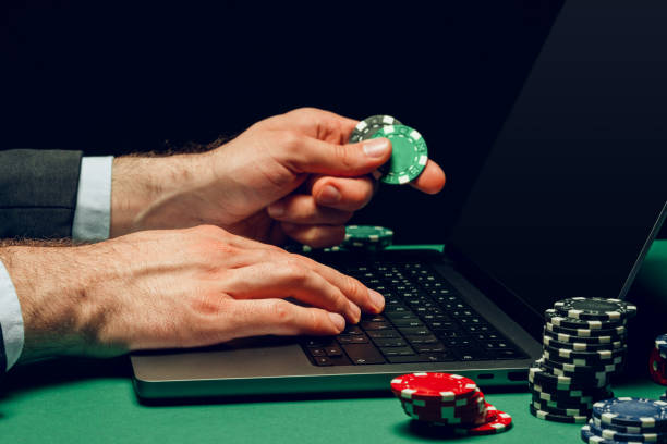 istock Person Playing Online Poker Game With Laptop and Chips 2161427875