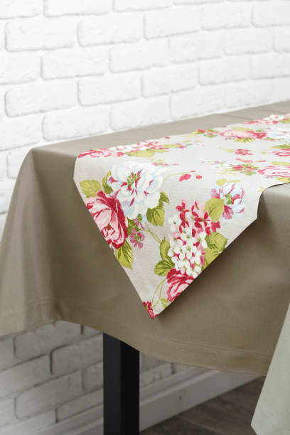 istock Floral Table Runner on a Beige Tablecloth Against a White Brick Wall 2161432512