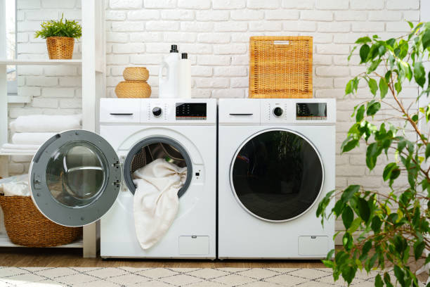 istock Open Washing Machine With Pink and Yellow Clothes in a Modern Laundry Room 2161432523
