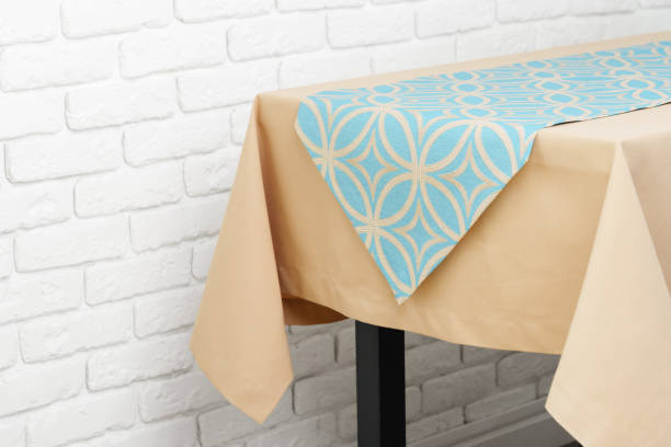 istock Beige Tablecloth on Wooden Table With White Brick Wall Background 2161432931