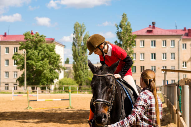 Adorable blonde little child girl stroking a pony, smiling and enjoying happy weekend outdoor. Children and love for animals