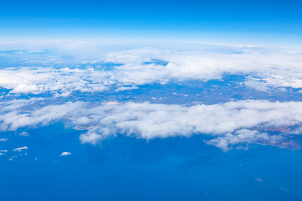 Aerial view of ocean and clouds from airplane window. Earth continent seen from above