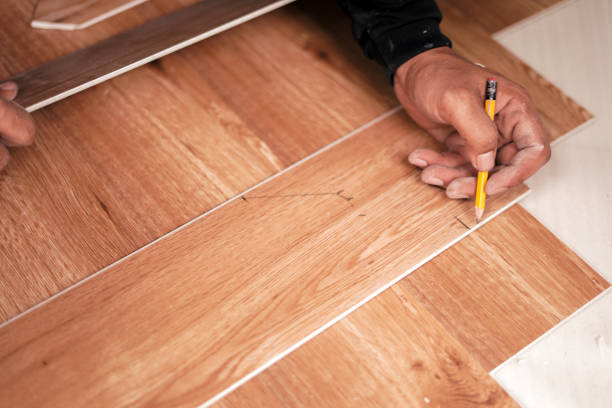 istock Hand holding a pencil and writing on Wood pattern pvc floor 2161435010