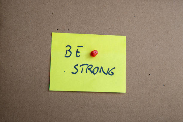 istock colored motivational post-it memo sheet with writing Be Strong with brown background 2161435113