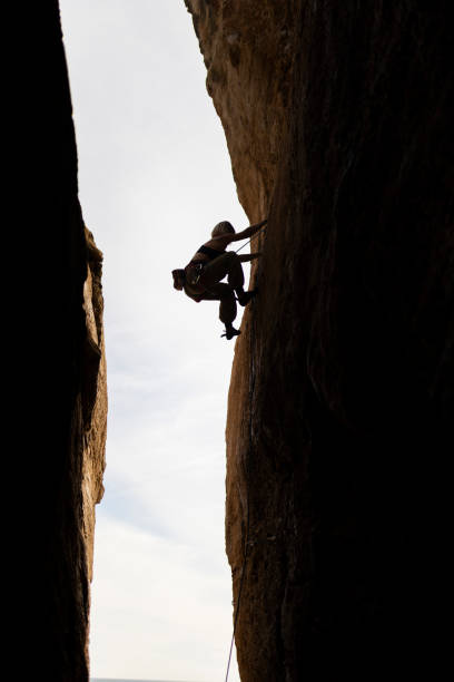istock A person is climbing a rock wall in a cave 2161435393