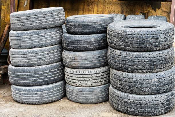 istock Stacked Used Tires Outside Building 2161437120