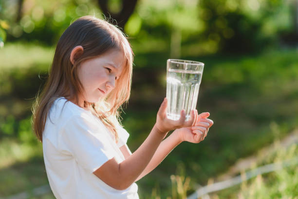 istock Child drinks water from a glass in nature 2161440736