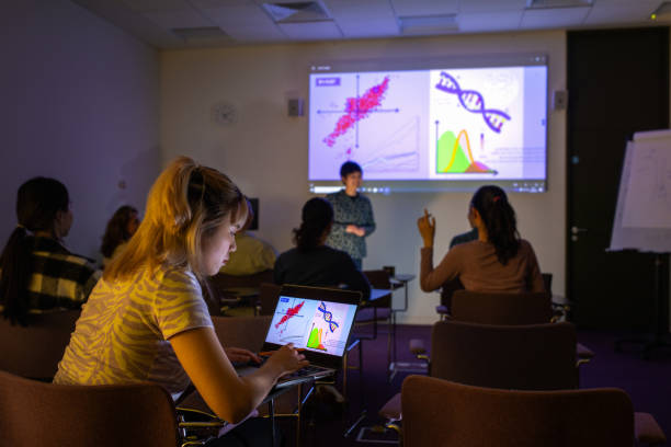 Diverse Students Listening A wide shot from the student's perspective of a university lecture, the girl in focus is on her laptop. The back of students' heads can be seen in the foreground and the projector is screening scientific data. The image was captured at a university campus in London.
Videos are available similar to this scenario. projector screen classroom stock pictures, royalty-free photos & images