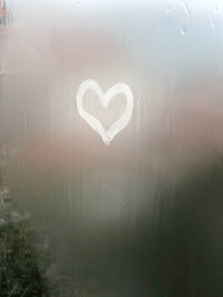 istock heart shape on steamed glass surface or window with rain drops in rainy day 2161448486