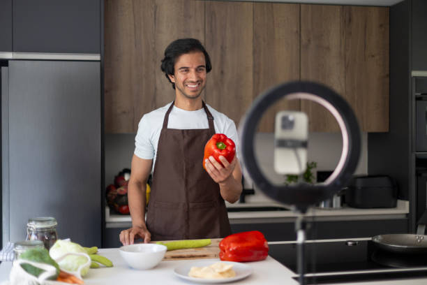 istock Smiling man holding a bell pepper, preparing food in a modern kitchen. 2161448725