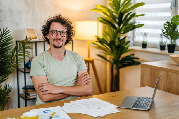 istock Mid-Adult Man Working On A Laptop While Sitting On The Kitchen Table At Home 2161450825