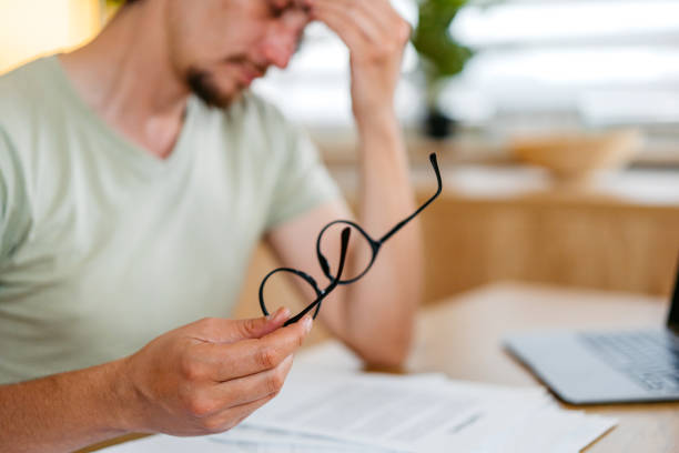 istock Mid-Adult Man Having A Headache While Working On A Laptop At The Kitchen Table At Home 2161451033