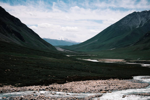 istock Tranquil light-blue river flowing along a lush summer mountain valley 2161452740