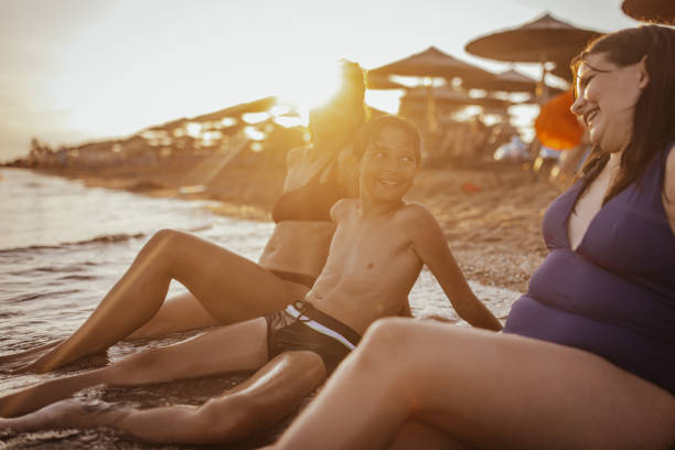 A family relaxes by the ocean on a sunlit beach during a vibrant sunset, capturing the essence of leisure, serenity, and the shared joy of being near the sea.