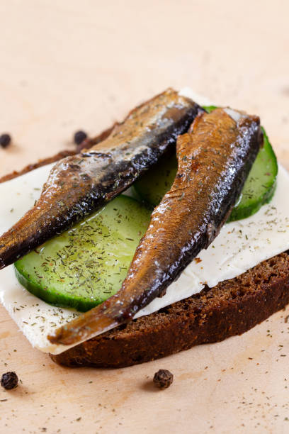 istock Sandwich black bread with sprats, cheese, cucumber and herbs. Snack for vodka 2161453484