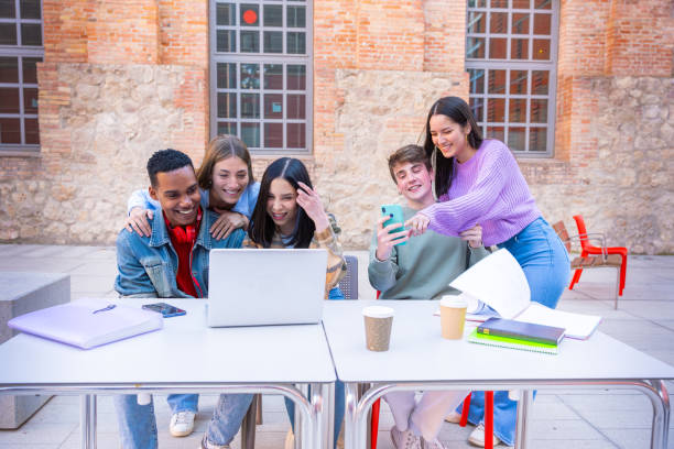 istock A group of students with laptops sit near the campus and communicate. 2161454351