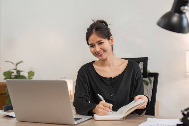 istock Professional Woman Working from Home with Laptop and Notebook in Modern Home Office Setting 2161455119