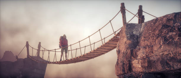 istock Hiker walking on a suspension bridge between mountains 2161455832