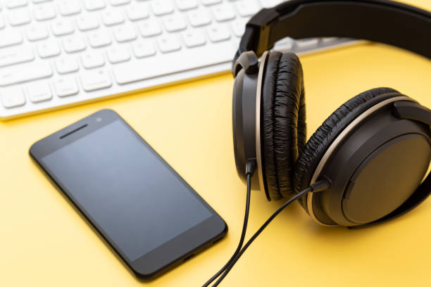 istock Headphones, computer and smartphone on a yellow background 2161456155