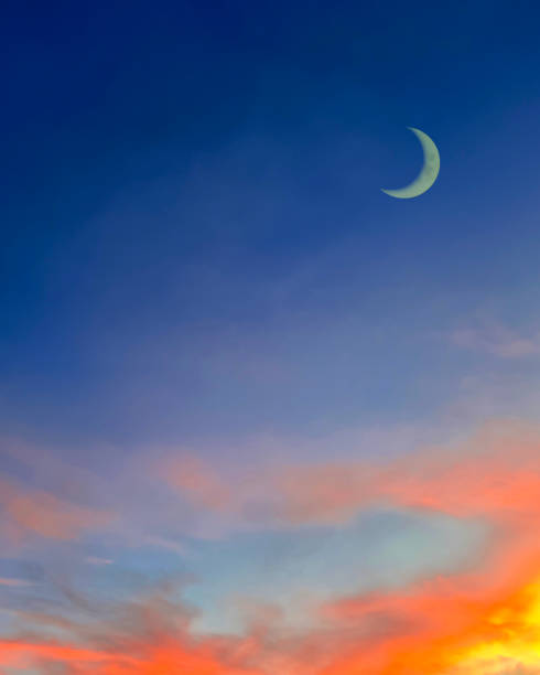 Islamic background with crescent moon in evening with colorful dusk sky, Ramadan blue night with dramatic sunset.