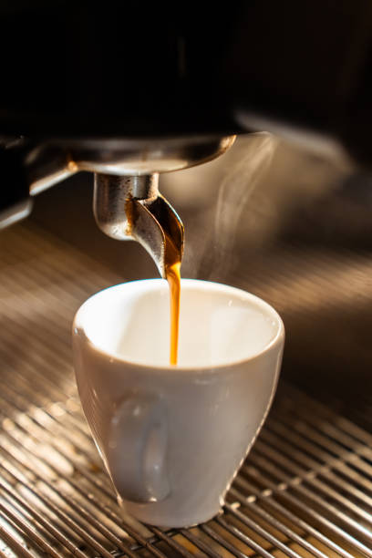 istock Isolated hot espresso coffee from machine to cup. Vertical 2161461004