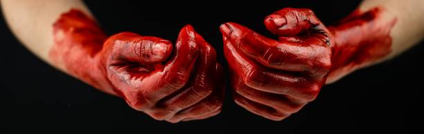 istock Women's hands in blood on a black background. 2161462965