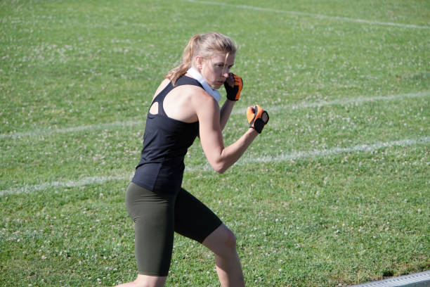 young sportive blond female boxer training , ready to punch